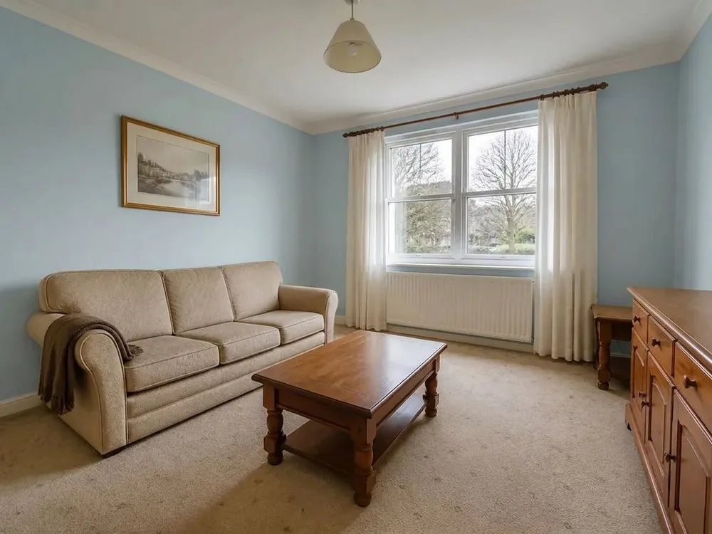 Zartblau · eine kühle Wand hinter demselben Sofa, das Tageslicht vom Fenster unverändert — after