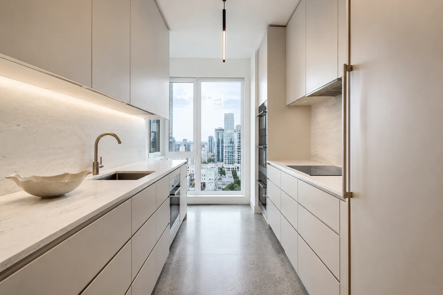 Restyled condo galley kitchen in Modern Minimal style with handleless greige fronts and pale stone counters